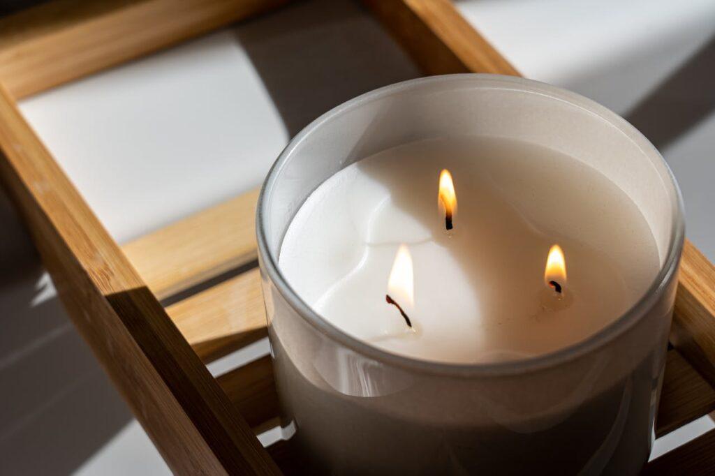 The Art of Drawing Readers In: Your attractive post title goes here Elegant three-wick candle with a warm glow on a wooden tray, perfect for a tranquil ambiance.